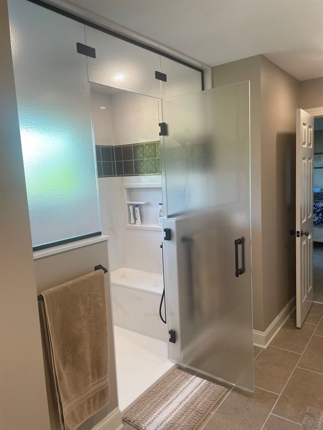 Walk-in tile shower with frosted glass and accent niche by Stellar Construction