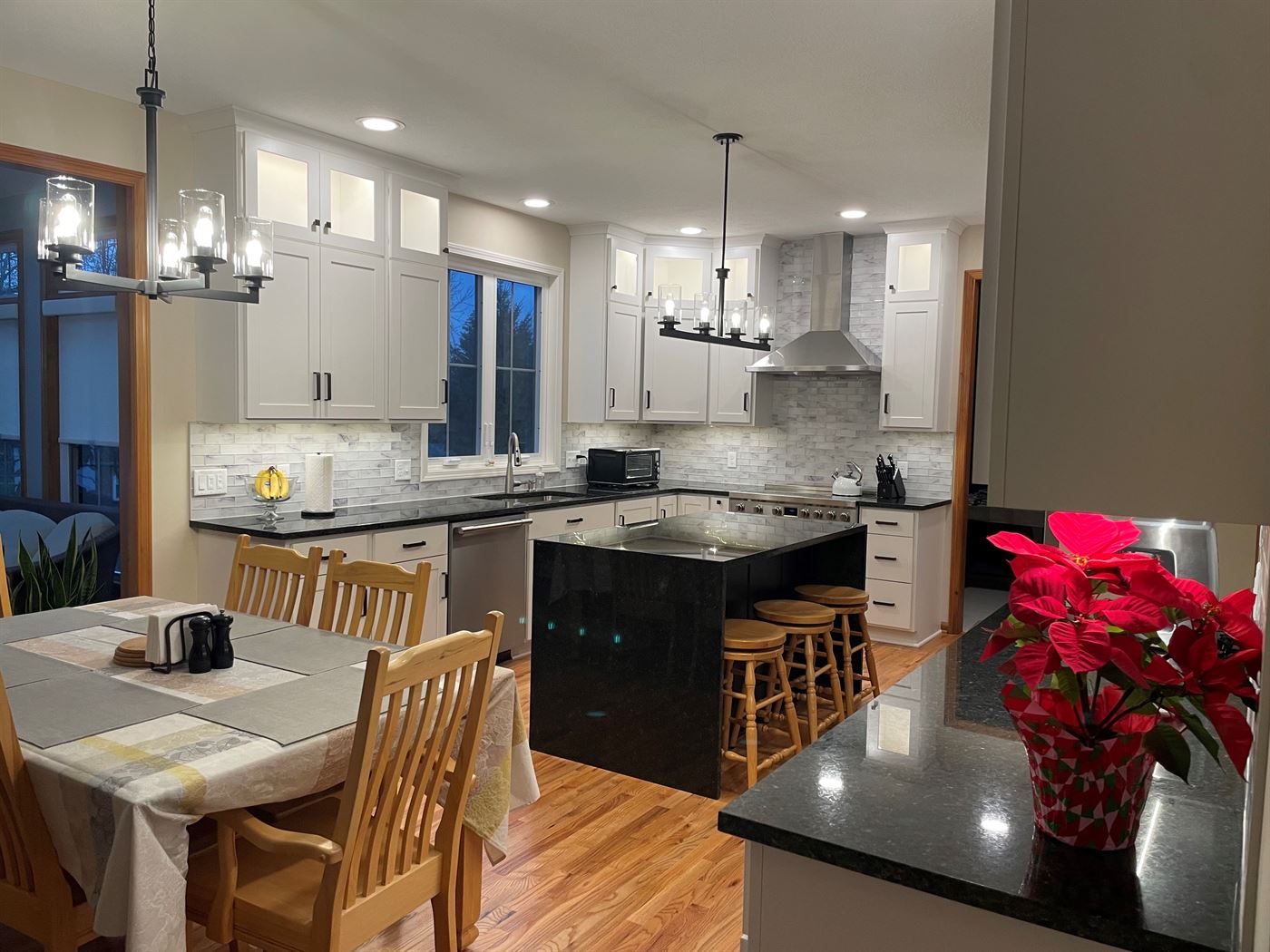 Open white kitchen with dining area by Stellar Construction