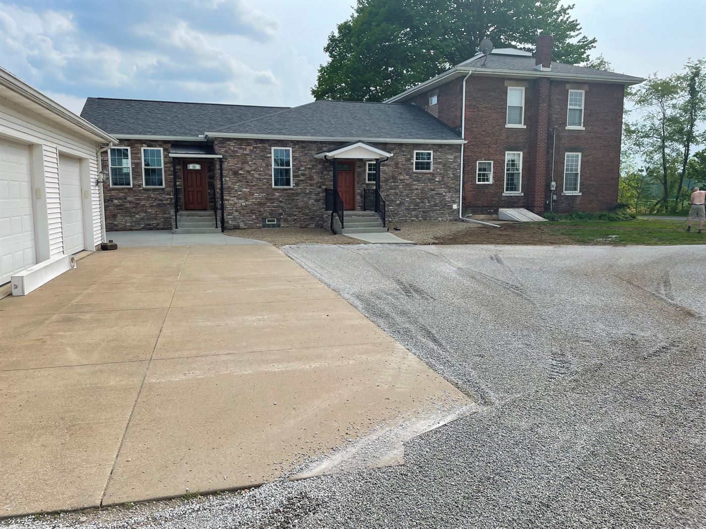 Stone-front first-floor addition joined to an existing brick home by Stellar Construction